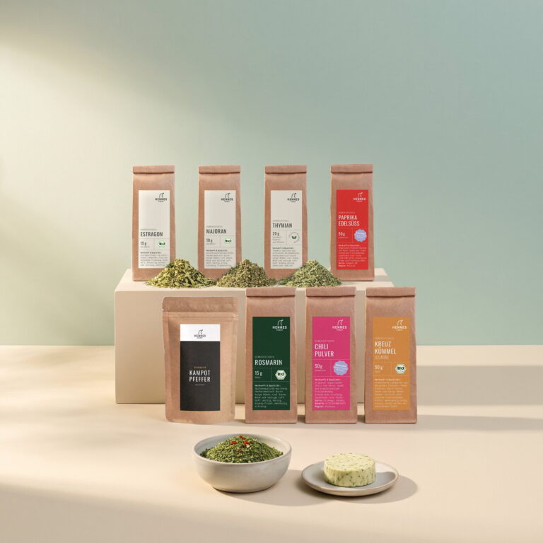 Café de Paris: Schale mit der Mischung, dahinter die Zutaten Estragon, Majoran, Thymian, Paprika edelsüß, schwarzer Kampot-Pfeffer, Rosmarin, Chilipulver und Kreuzkümmel im Gewürzstudio-Beutel